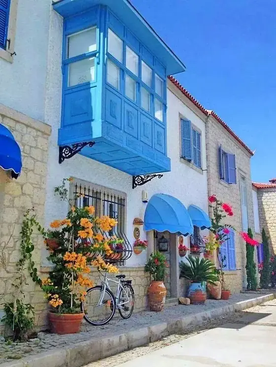 Alaçatı'da mavi cumbalı, çiçekli taş evlerin olduğu sokak