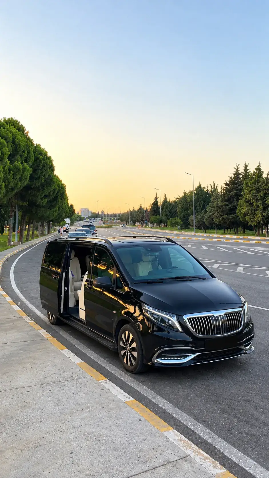 Gün batımında yol kenarında bekleyen siyah Mercedes Vito VIP, yan kapısı açık